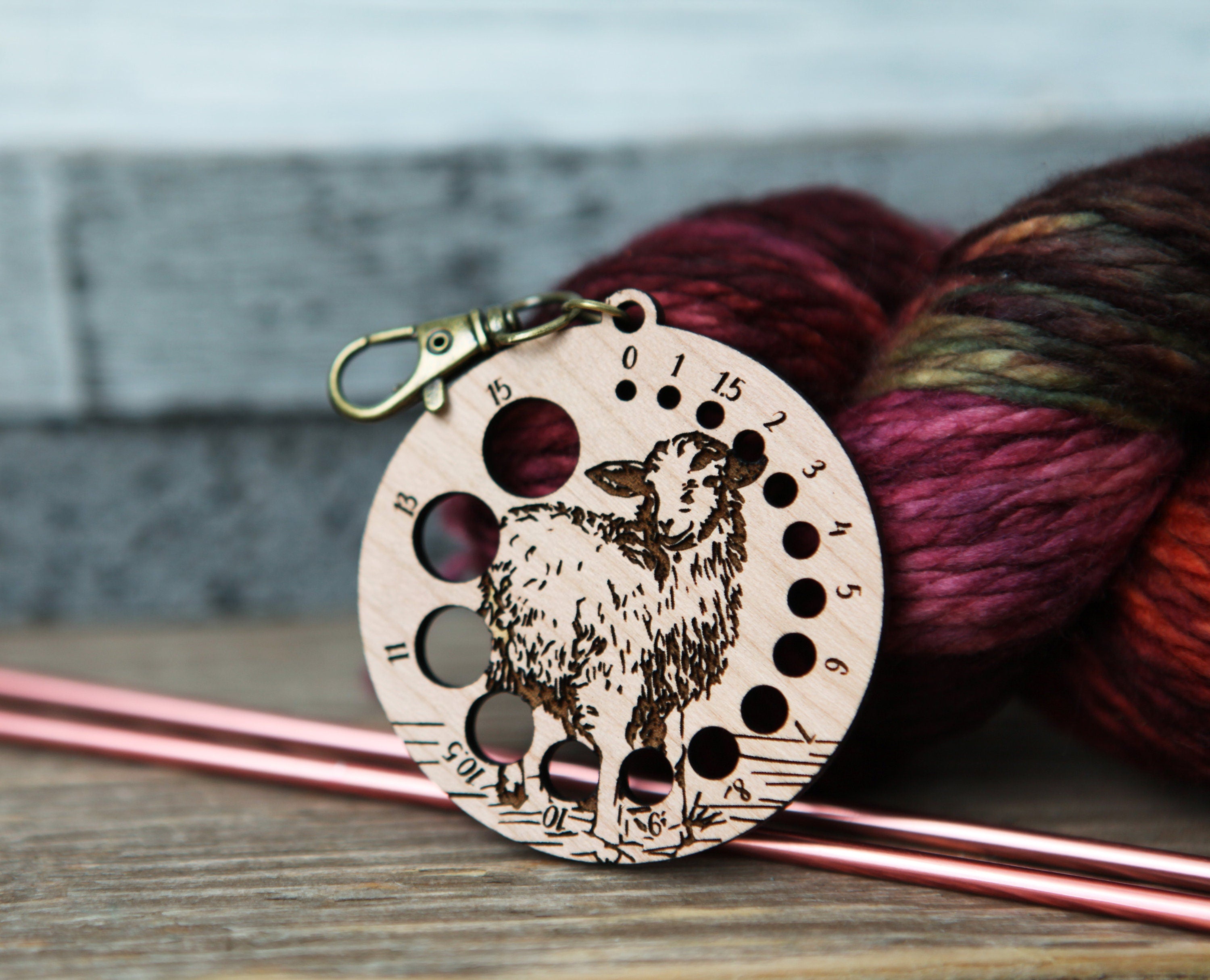 Knitting Needle Gauge Guide with a sheep standing on a grassy hill - Cherry wood with bronze clasp
