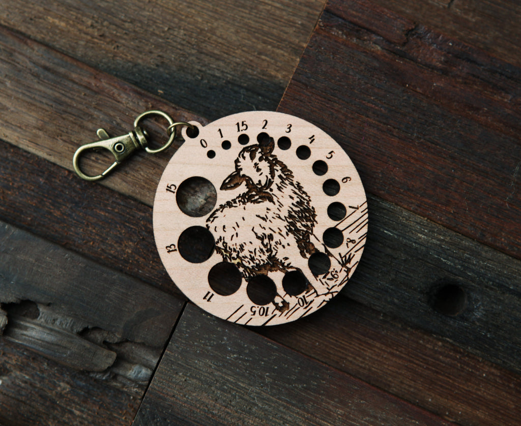 Knitting Needle Gauge Guide with a sheep standing on a grassy hill - Cherry wood with bronze clasp