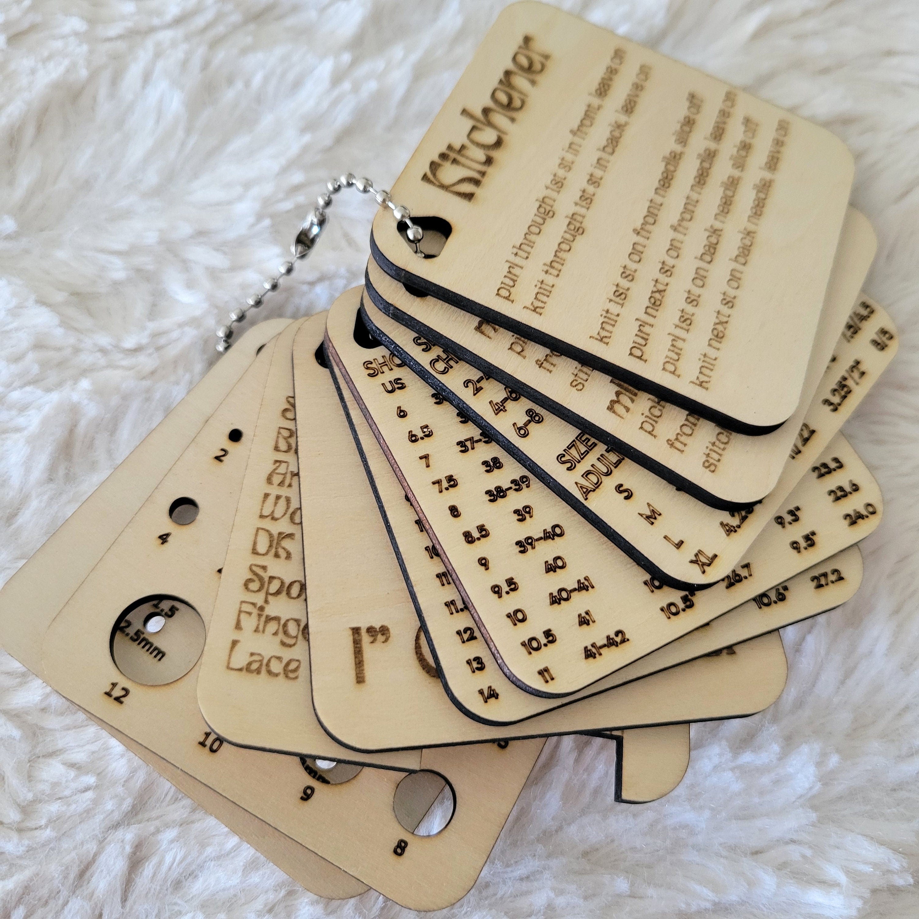 Keychain Knitting Tools for measuring gauge, measuring knitting needles, instructions for stitches, measuring yarn, and sizing help